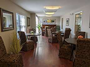 A living room with brown patterned chairs and a wooden floor.