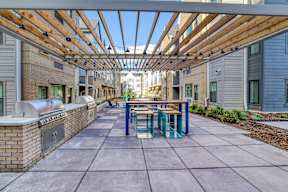 A long covered walkway with benches and a brick wall on one side.