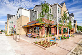 A modern apartment complex with a central courtyard and seating area.