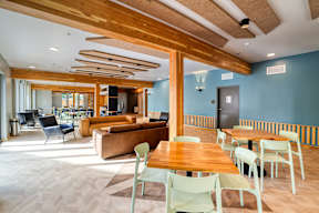A modern living room with a wooden ceiling and furniture.