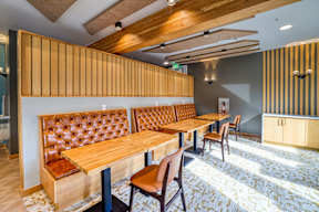 A wooden table with chairs in a room with a wooden ceiling.