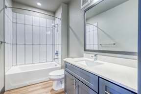 A white toilet sits next to a white sink in a modern bathroom.