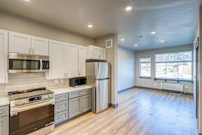 A kitchen with white cabinets and a stainless steel refrigerator.