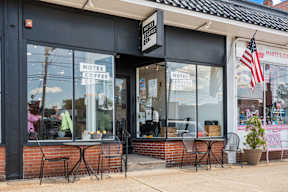 A storefront with a sign that reads "Notes Coffee Coffee".
