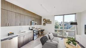 a living room with a kitchen and a large window