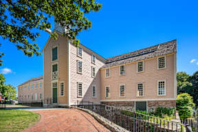A large building with a brick walkway in front.