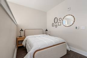 A bedroom with a large bed and a mirror on the wall.