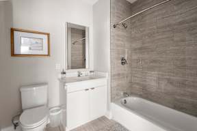 A bathroom with a white toilet, a white sink, and a white bathtub.