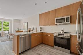 A modern kitchen with wooden cabinets and stainless steel appliances.