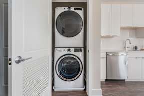 A white front loading washing machine is in a doorway.