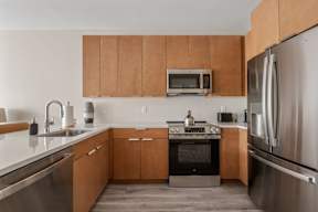 A modern kitchen with wooden cabinets and stainless steel appliances.
