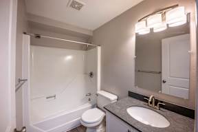 Kent apartment bathroom with bathrub and mirror with bright lighting