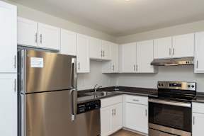 Adams Village apartments kitchen with white cabinets and stainless appliances