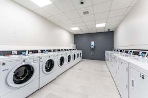 a washer and dryer laundry room with rows of washes and dryers