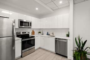 A modern kitchen with stainless steel appliances and white cabinets.