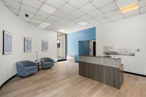 A reception area with a blue accent wall and a wooden floor.