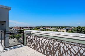 A balcony with a metal railing overlooks a cityscape.