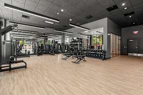 A gym with a variety of equipment including treadmills, weights, and exercise machines.