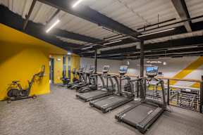 a room filled with lots of cardio equipment and weights