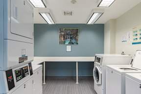 A laundry room with washing machines and a table.