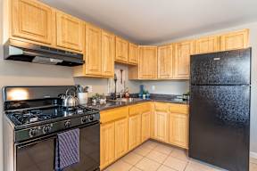 a kitchen with black appliances and wooden cabinets