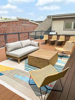 a furnished patio with a couch and chairs and tables