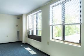 A room with a window and a wall-mounted speaker.