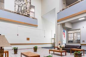 A white room with a wooden table and a painting on the wall.