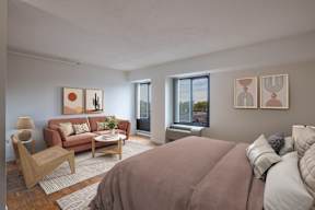 A bedroom with a large bed and a couch with pillows.