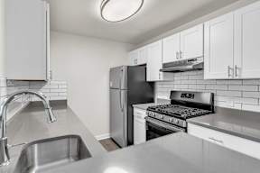 A kitchen with a refrigerator, stove, and oven in loft apartment at Ledges Apartments.