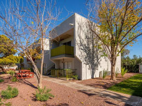 a house with a white facade and a green balcony