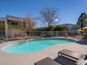a pool with a fence around it and a building in the background