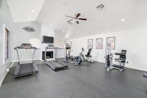 A spacious gym with treadmills, exercise bikes, and other equipment.