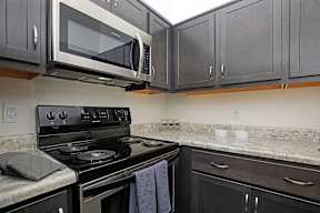 A kitchen with a black stove and microwave.