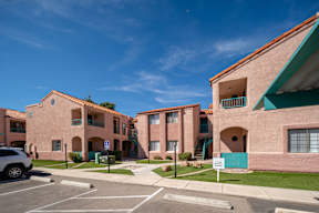 A sunny day at a residential complex with a car parked in the driveway.