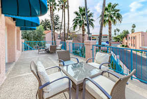 A patio with a table and chairs overlooking a street.