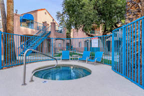 A pool area with a blue fence and a small pool.