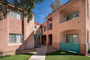 A pink building with a green staircase.