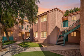A building with a green staircase and a tree in front.