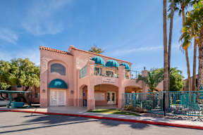 A pink building with a blue awning and a white door.
