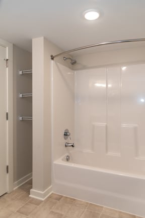 A white bathroom with a tub, shower, and a door.