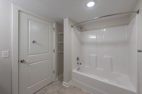 A white bathroom with a tub and shower.