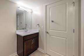 A white bathroom with a sink and mirror.