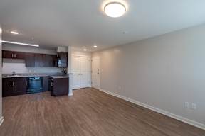 A kitchen with dark wood cabinets and a black fridge.