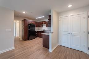 A kitchen with white cabinets and a black fridge.