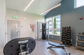 a gym with a reformer and weights and a window