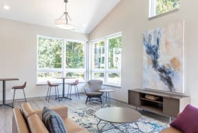 a living room with a couch and a table with chairs and a large window