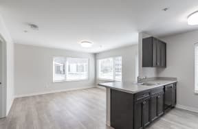 an empty kitchen with a sink and counter top in a new home