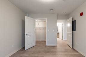 a bedroom with a door open to a bathroom and a closet