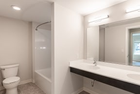 a bathroom with a large mirror and a toilet and a sink